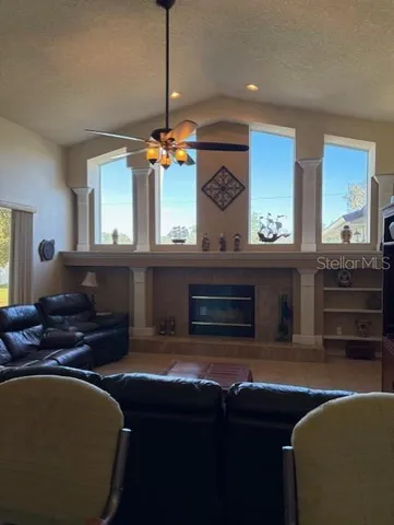 a living room with furniture a flat screen tv and kitchen view