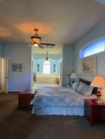 a bedroom with a large bed and a chandelier