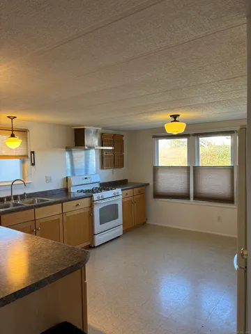 a kitchen with stainless steel appliances a stove a sink and a microwave