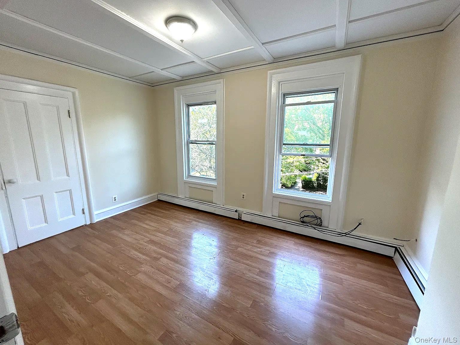 9 Grand Street, Unit 2 Poughkeepsie, NY 12601 - Photo 4 of 7 an empty room with wooden floor and windows