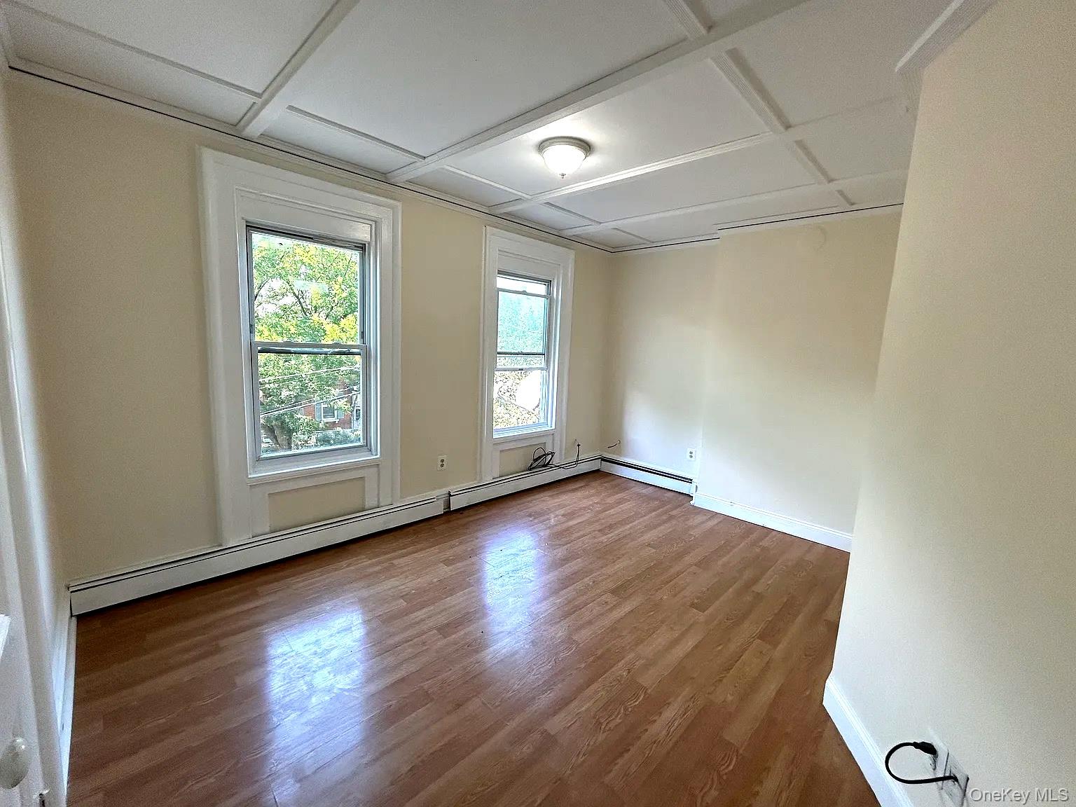 9 Grand Street, Unit 2 Poughkeepsie, NY 12601 - Photo 5 of 7 an empty room with wooden floor and windows