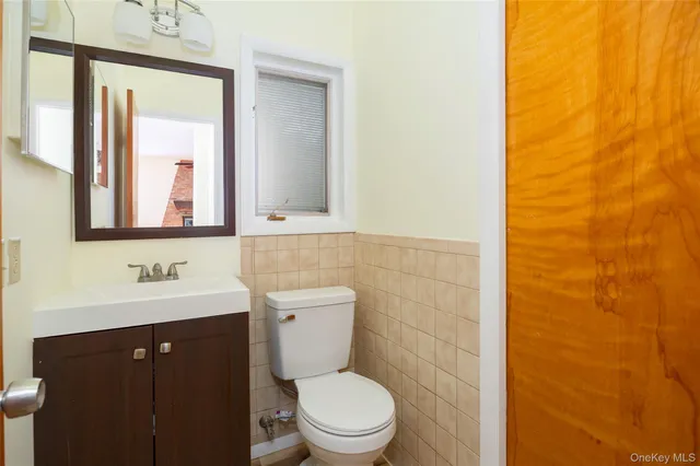 a bathroom with a toilet a sink and mirror