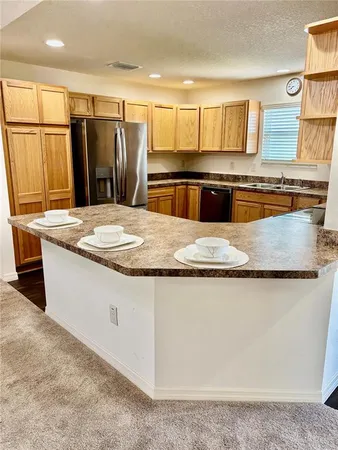 a kitchen with stainless steel appliances granite countertop a sink a stove and a refrigerator