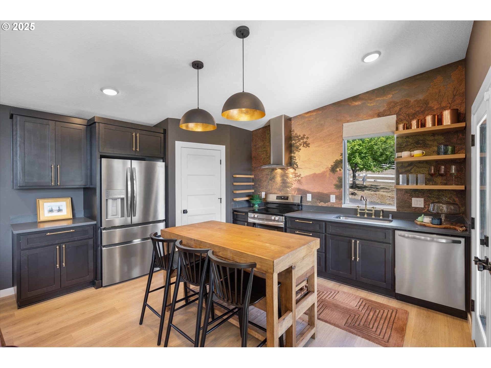 810 Taylor Road Kalama, WA 98625 - Photo 3 of 35 a kitchen with stainless steel appliances granite countertop a kitchen island a stove a refrigerator a dining table and chairs with wooden floor