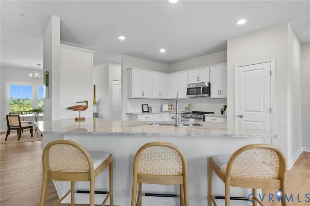 a living room with furniture a dining table wooden floor and a large window