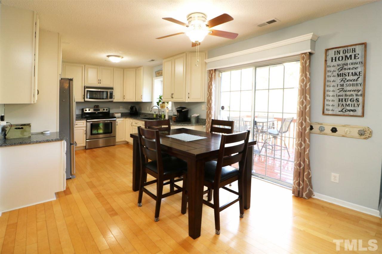 4517 Drewbridge Way Raleigh, NC 27604 - Photo 13 of 30 a kitchen with stainless steel appliances kitchen island granite countertop a table chairs sink and cabinets