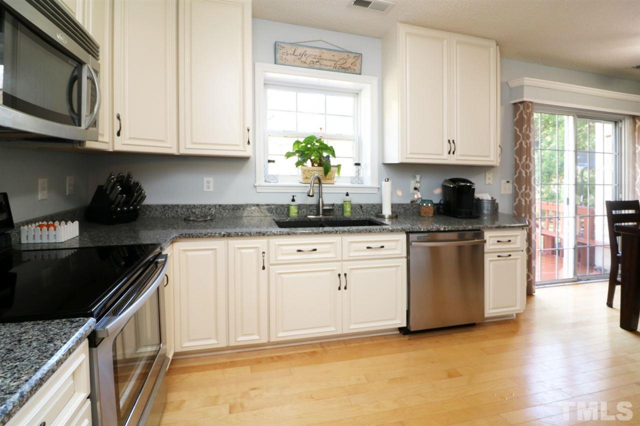 4517 Drewbridge Way Raleigh, NC 27604 - Photo 16 of 30 a kitchen with granite countertop white cabinets sink and stainless steel appliances