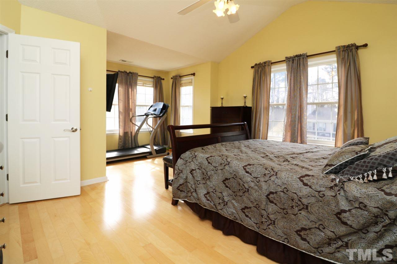 4517 Drewbridge Way Raleigh, NC 27604 - Photo 23 of 30 a bedroom with a bed and wooden floor