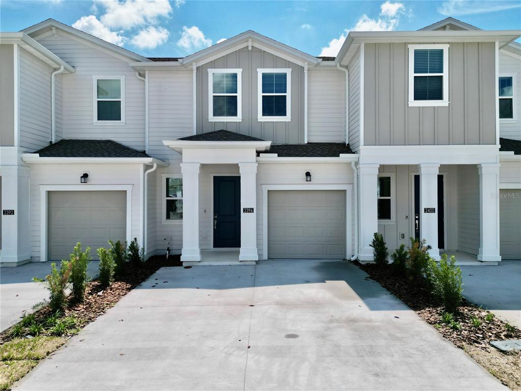 2396 Brook Marsh Loop Kissimmee, FL 34747 - Photo 1 of 29 a view of a white house with potted plants in front of it