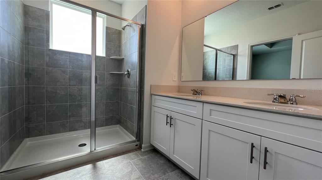 2396 Brook Marsh Loop Kissimmee, FL 34747 - Photo 20 of 29 a bathroom with a shower sink and mirror