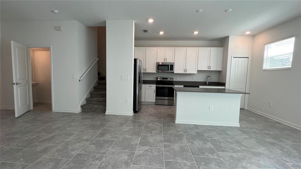 2396 Brook Marsh Loop Kissimmee, FL 34747 - Photo 25 of 29 a kitchen with stainless steel appliances granite countertop a stove a sink and a refrigerator