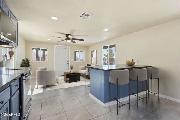 a living room with furniture a dining table and chairs with wooden floor