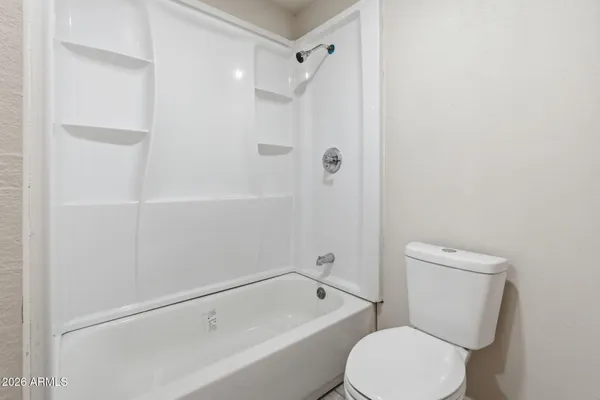 a white toilet and tub sitting next to a bathroom sink