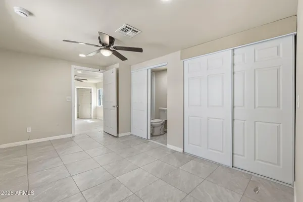 a view of an empty room and chandelier fan