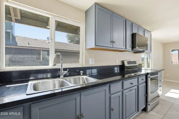 a kitchen with stainless steel appliances granite countertop a sink stove and cabinets