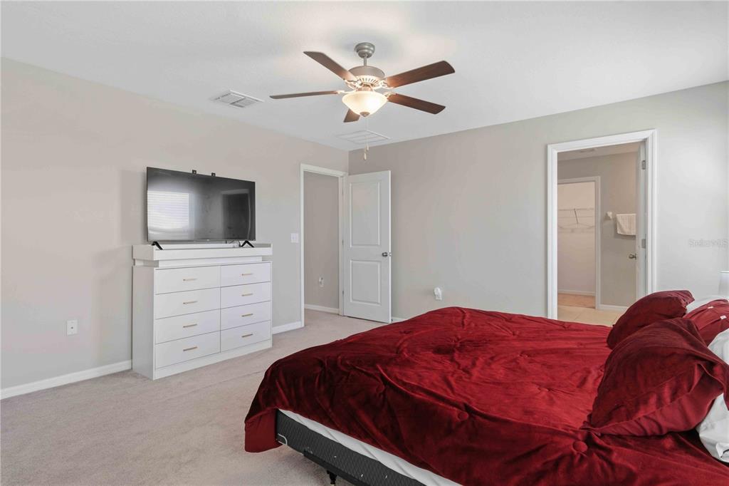 9440 Lemon Drop Loop Sun City Center, FL 33573 - Photo 32 of 55 a bedroom with a bed and a flat screen tv