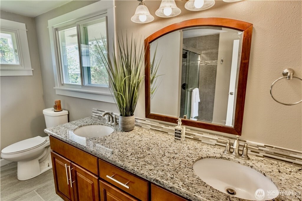 2241 South 252nd Street Des Moines, WA 98198 - Photo 13 of 25 a bathroom with a granite countertop sink a toilet and mirror
