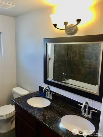 a bathroom with a granite countertop sink and a mirror