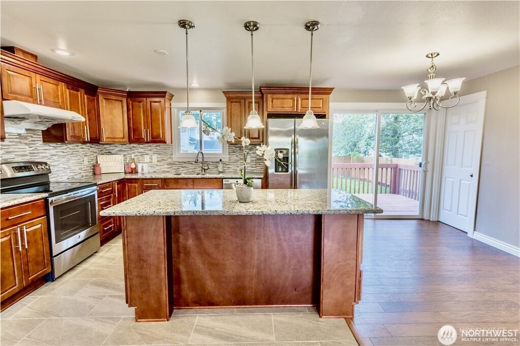 2241 South 252nd Street Des Moines, WA 98198 - Photo 8 of 25 a kitchen with stainless steel appliances granite countertop wooden cabinets a stove top oven a sink and dishwasher