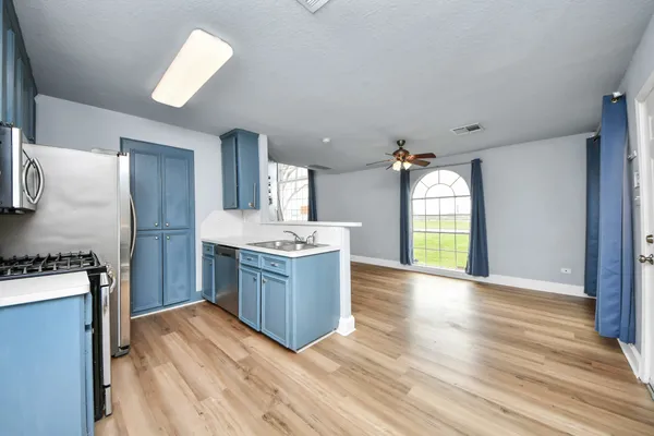 a kitchen with granite countertop a stove a sink and a refrigerator