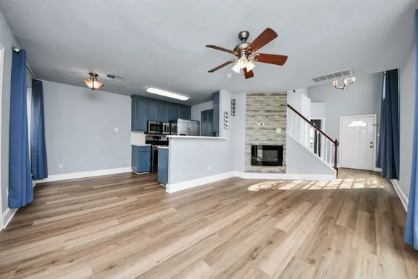 a view of a kitchen with wooden floor and a ceiling fan
