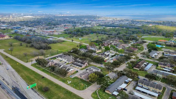 an aerial view of residential houses with outdoor space and trees