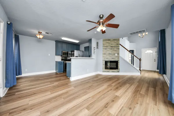a view of empty room with wooden floor and fireplace