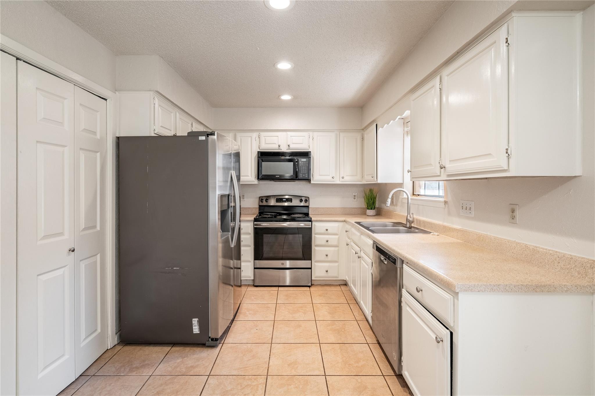 3800 Foust Trail, Unit B Georgetown, TX 78628 - Photo 4 of 16 A well-equipped galley kitchen offers ample cabinetry, neutral countertops, and essential appliances.