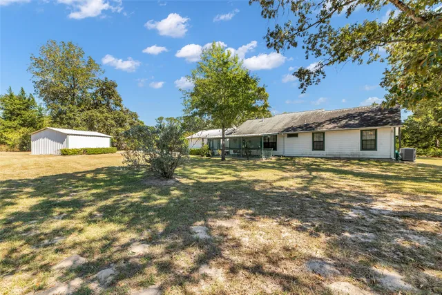 a front view of house with yard and trees around