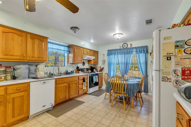 a kitchen with stainless steel appliances granite countertop sink stove top oven and cabinets