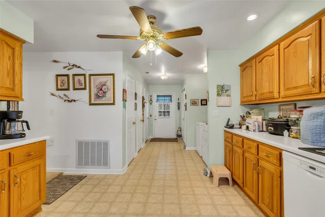 a kitchen with granite countertop a sink cabinets stainless steel appliances and a window