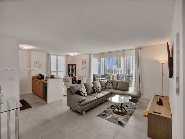 a living room with furniture and a floor to ceiling window