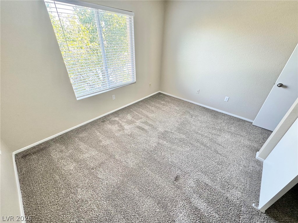 8070 West Russell Road, Unit 2121 Las Vegas, NV 89113 - Photo 10 of 22 A quiet bedroom offers plush carpeting and a large window with privacy blinds.