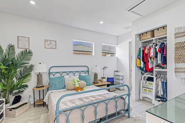 a bedroom with a bed and a potted plant