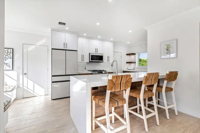 a kitchen with stainless steel appliances kitchen island granite countertop a refrigerator and a stove top oven