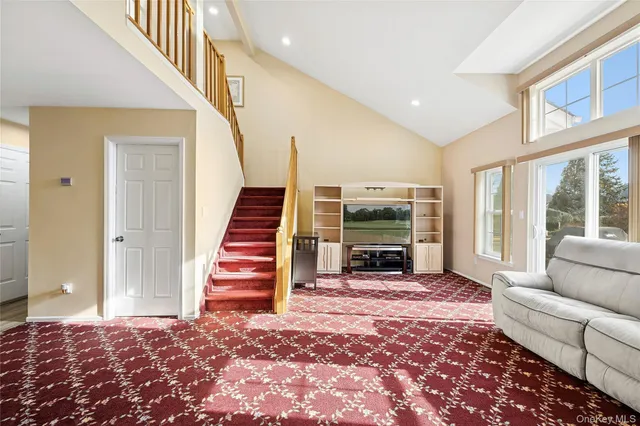 a view of a livingroom with wooden floor and stairs