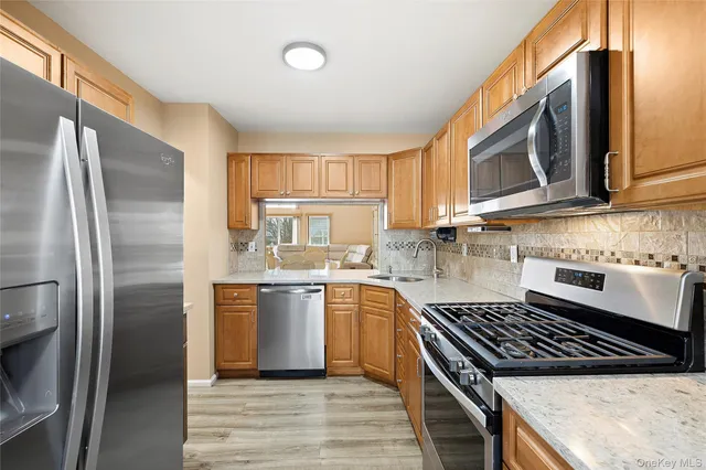 a kitchen with stainless steel appliances granite countertop a stove a refrigerator and a sink