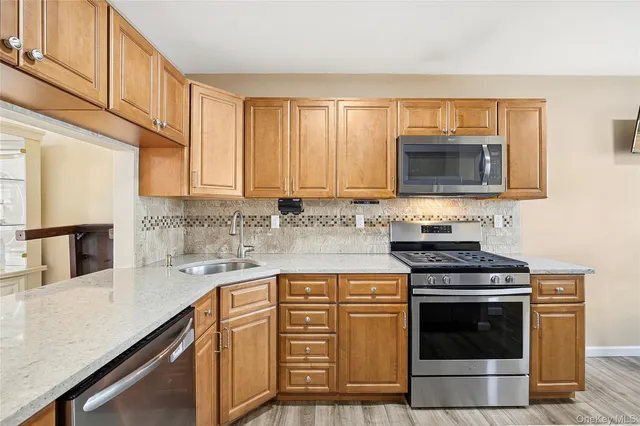 a kitchen with stainless steel appliances a stove sink microwave and cabinets