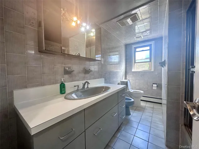 a bathroom with a sink a toilet and a mirror
