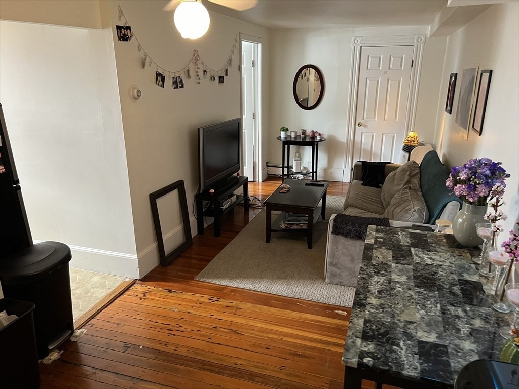137 Peterborough Street, Unit 31 Boston, MA 02215 - Photo 5 of 14 a living room with furniture wooden floor and a flat screen tv