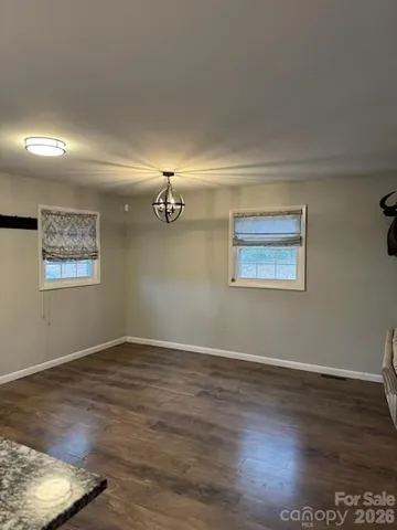 a kitchen with stainless steel appliances granite countertop a refrigerator a sink dishwasher a stove with white cabinets and wooden floor