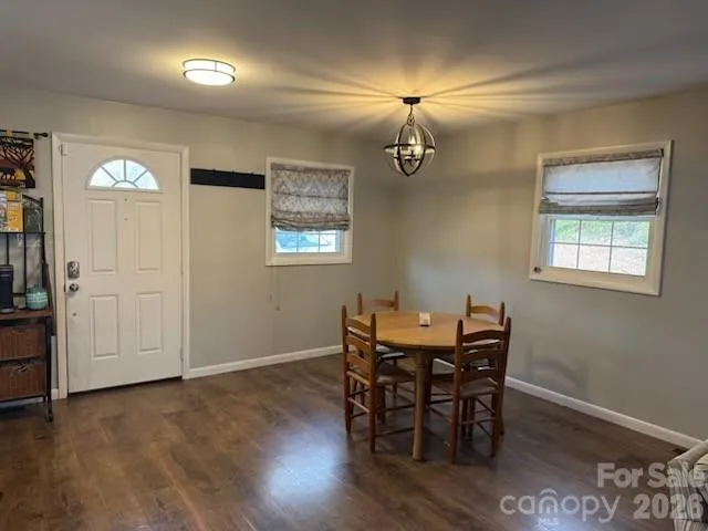 a kitchen with kitchen island granite countertop a stove a sink a dining table and chairs