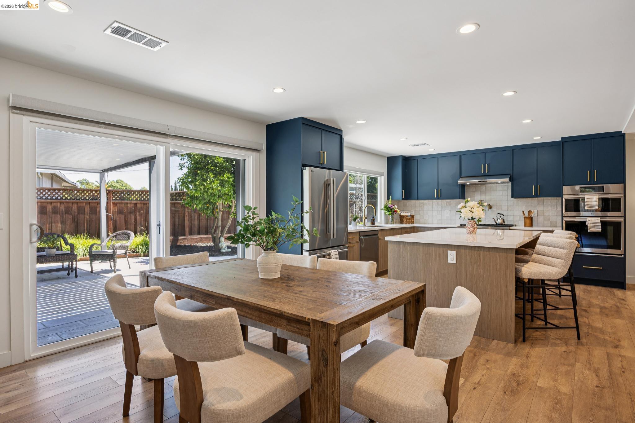 11 Belinda Court San Ramon, CA 94583 - Photo 12 of 33 Open-concept kitchen and dining area featuring wood-finish flooring, recessed lighting, and a sliding glass door to the exterior deck