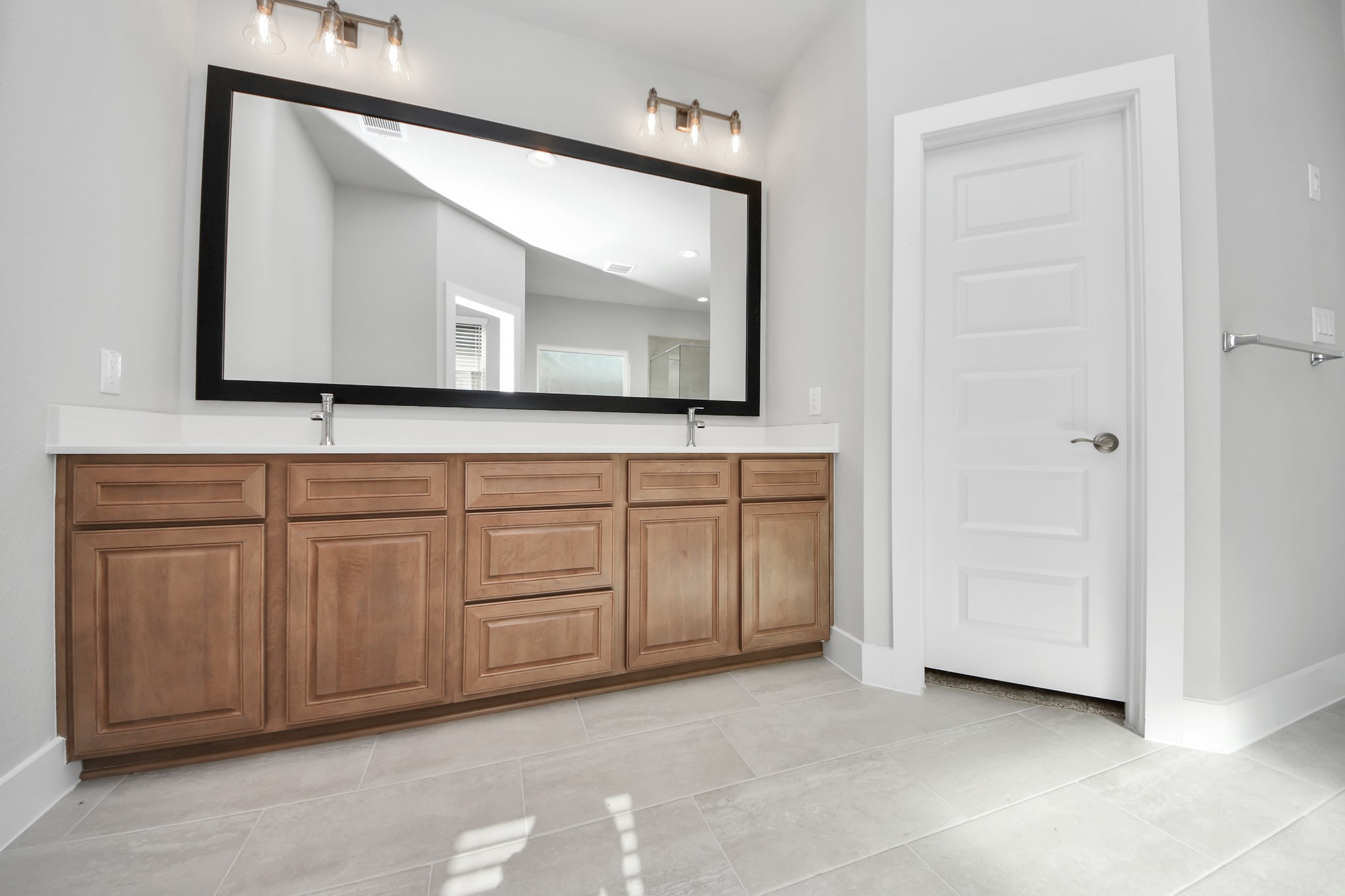 3102 Native Spg Drive Spring, TX 77373 - Photo 25 of 40 Elevate your daily routine at the elegant vanity, now equipped with double sinks, light countertops, modern hardware, and beautiful vanity lights. Sample photo of completed home with similar floor plan. Actual colors and selections may vary.