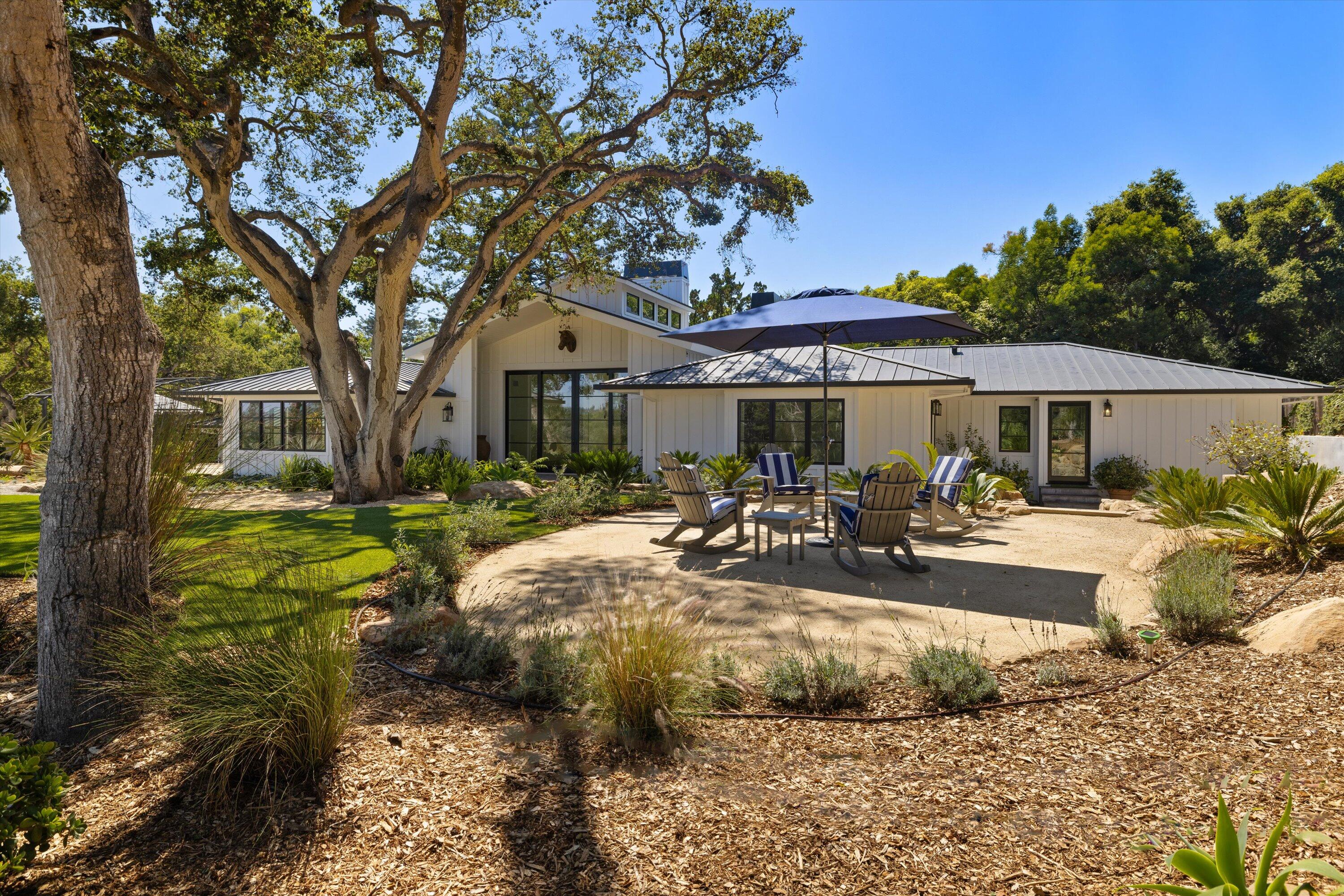 a view of a house with backyard and sitting area