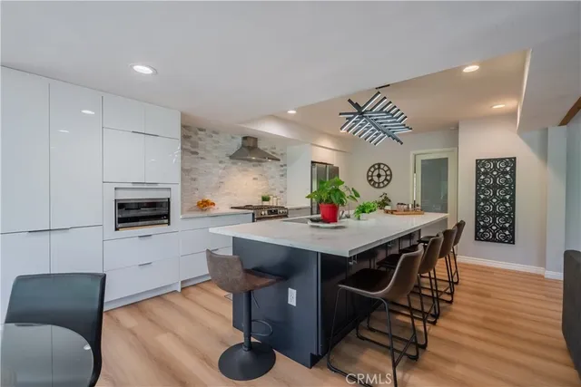 a kitchen with granite countertop a table chairs stove a sink and dishwasher