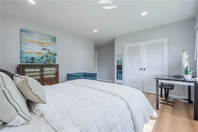 a bedroom with a bed a table and painting on the wall