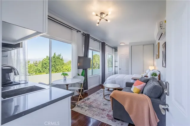 a bed room with a bed and a view of kitchen