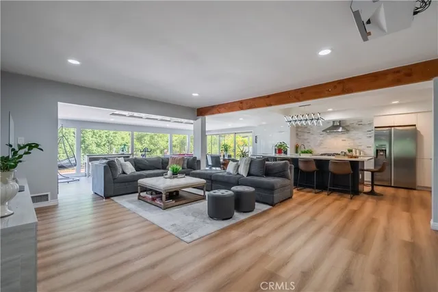 a living room with furniture wooden floor and a large window