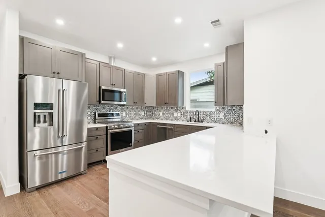 a kitchen with stainless steel appliances a refrigerator sink and microwave